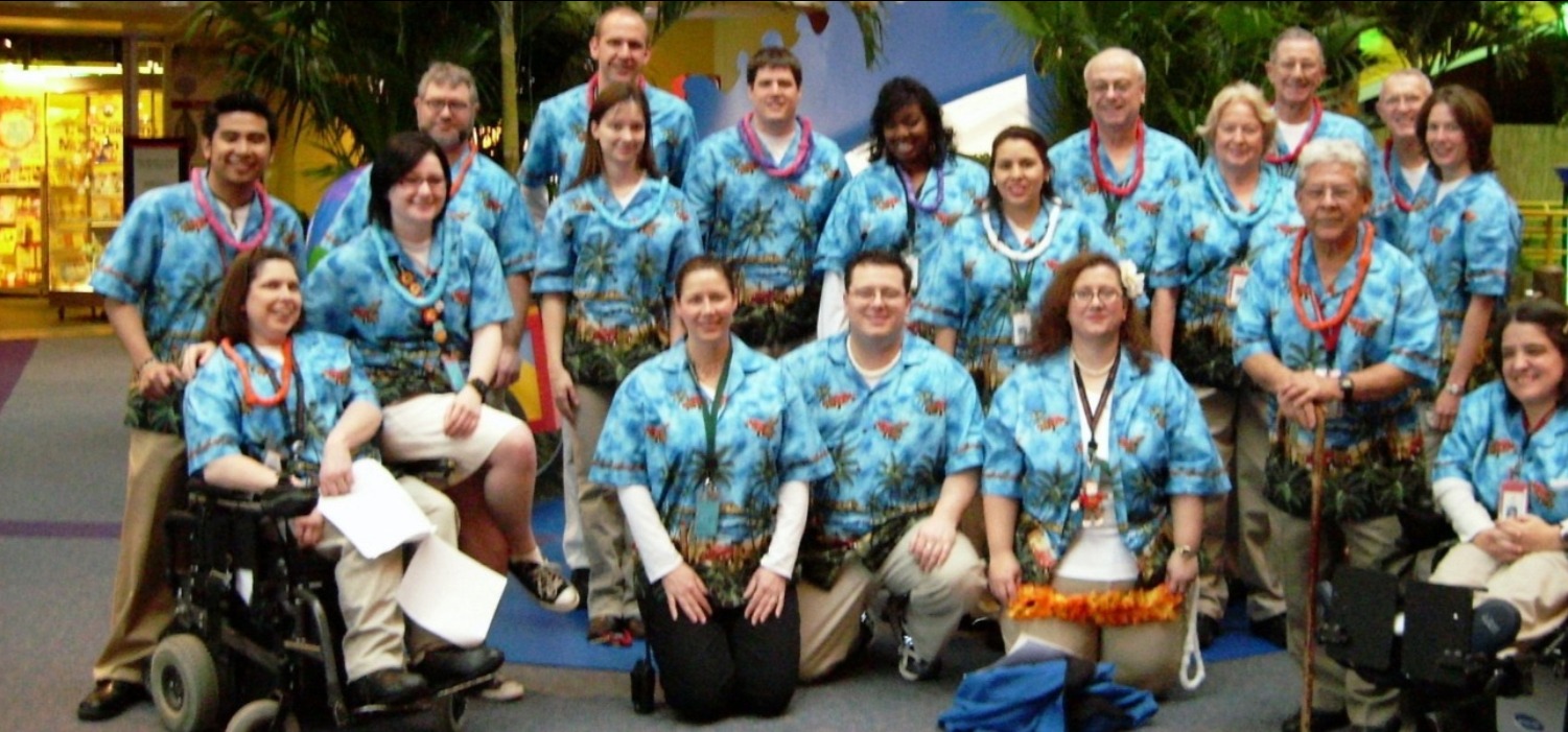 Group photograph of the staff at the Children's Museum of Indianapolis. They are wearing blue Hawaiian shirts adorned with Volkswagen beetles. The museum purchased these cotton Hawaiian shirts in bulk from our Group Sales department.