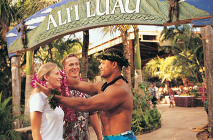 A man and a women receiving a flower lei at a luau.